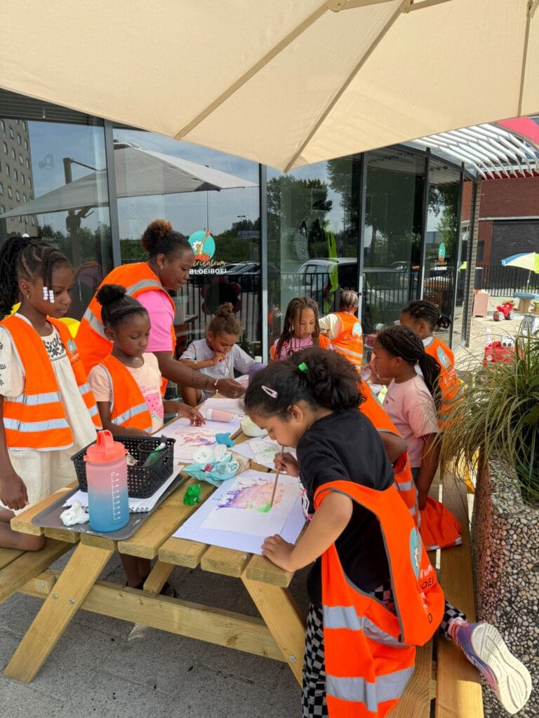 Bij Kindercentrum De Bloeiboei knutselen kinderen van de buitenschoolse opvang onder toezicht van een pedagogisch medewerker.