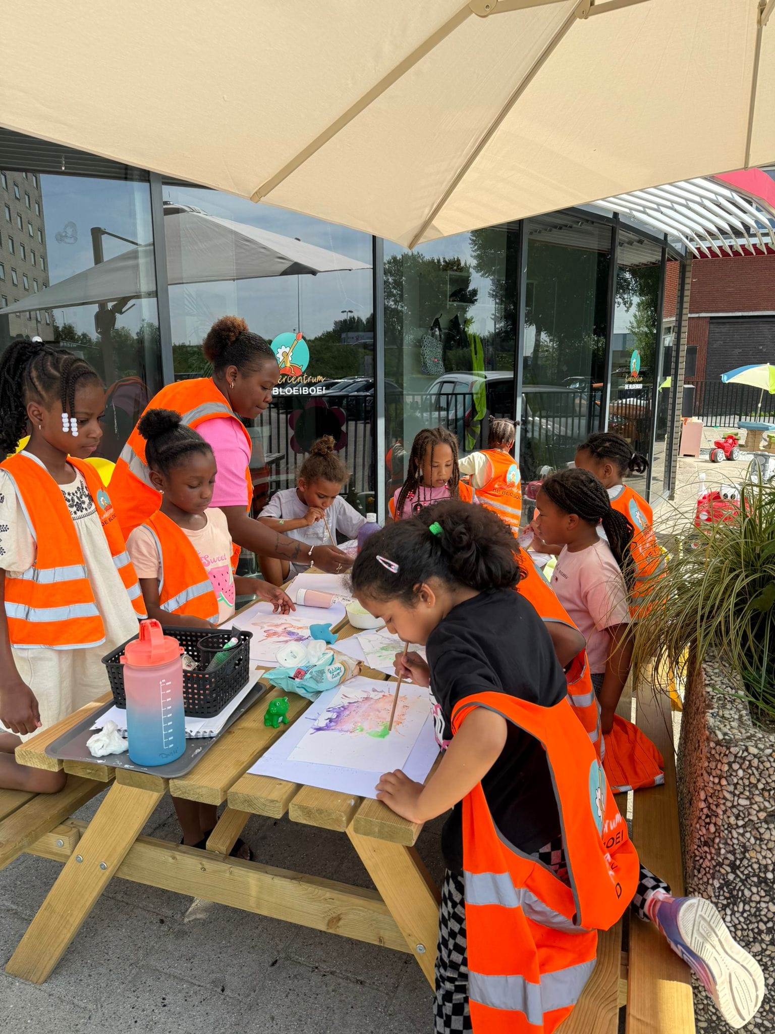 Bij Kindercentrum De Bloeiboei knutselen kinderen van de buitenschoolse opvang onder toezicht van een pedagogisch medewerker.